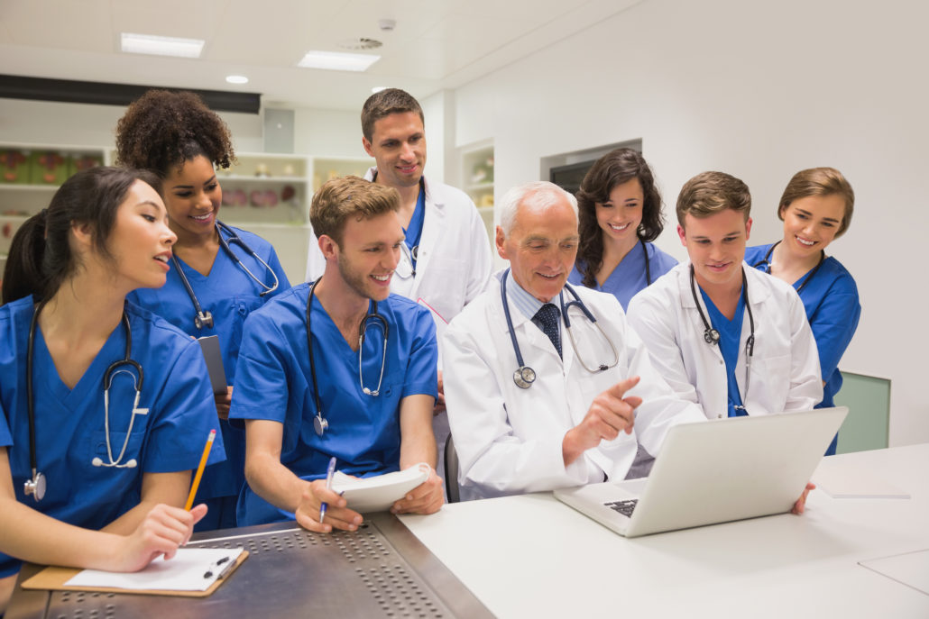 Medical students and professor using laptop at the university ...